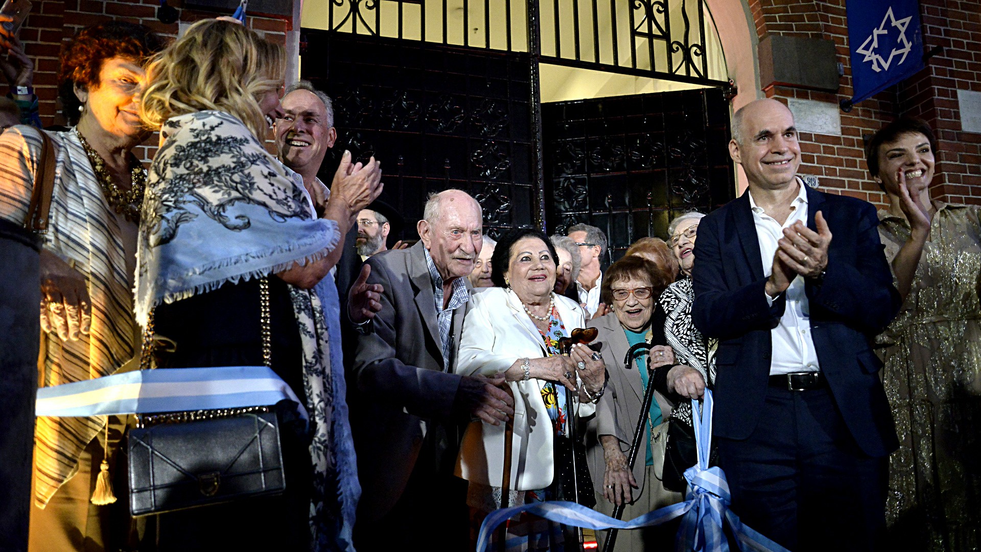 El momento del corte de cinta, el jefe de Gobierno, el presidente del Museo del Holocausto con los sobrevivientes miembros de la comitiva