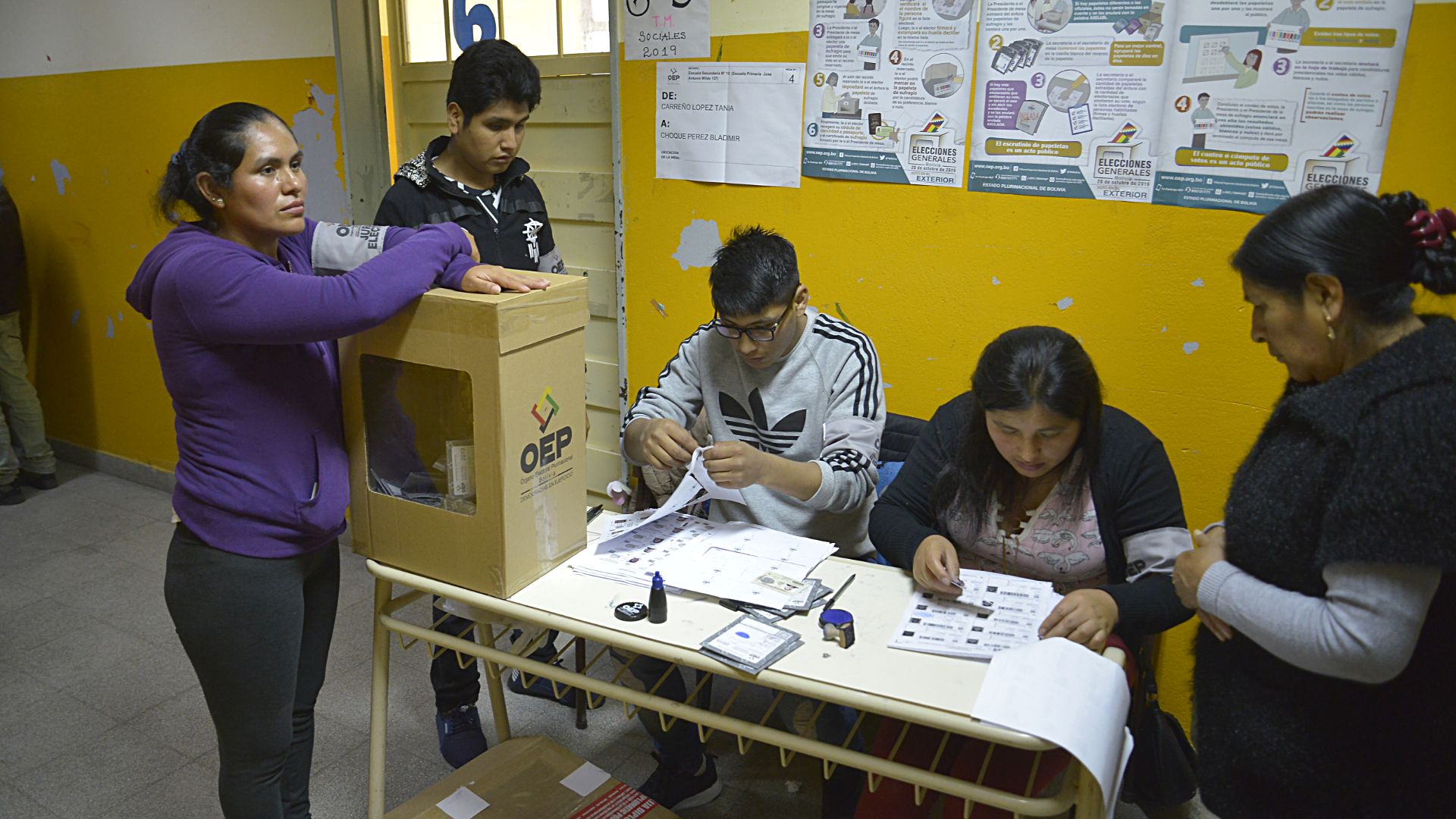 Las urnas están todo el tiempo custodiadas por los fiscales, quienes tapan con el antebrazo la boca de la urna y solamente la habilitan al momento que el ciudadano introduce su opción de voto