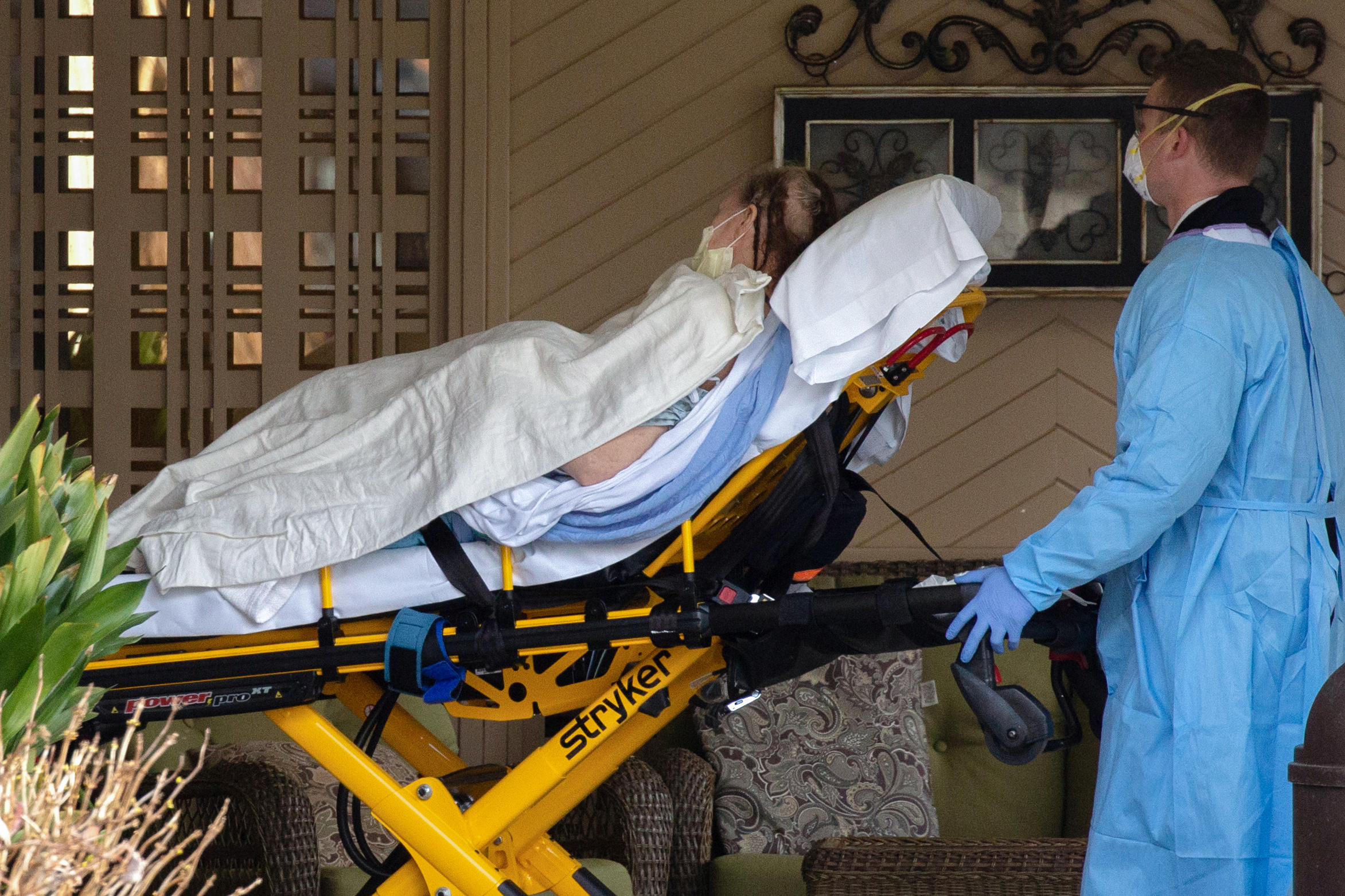 Médicos transportan a un paciente desde una ambulancia al Life Care Center de Kirkland, el centro de atención a largo plazo vinculado a casos confirmados de coronavirus en el estado, durante el brote de la enfermedad por coronavirus (COVID-19), en Kirkland, Washington (Reuters)