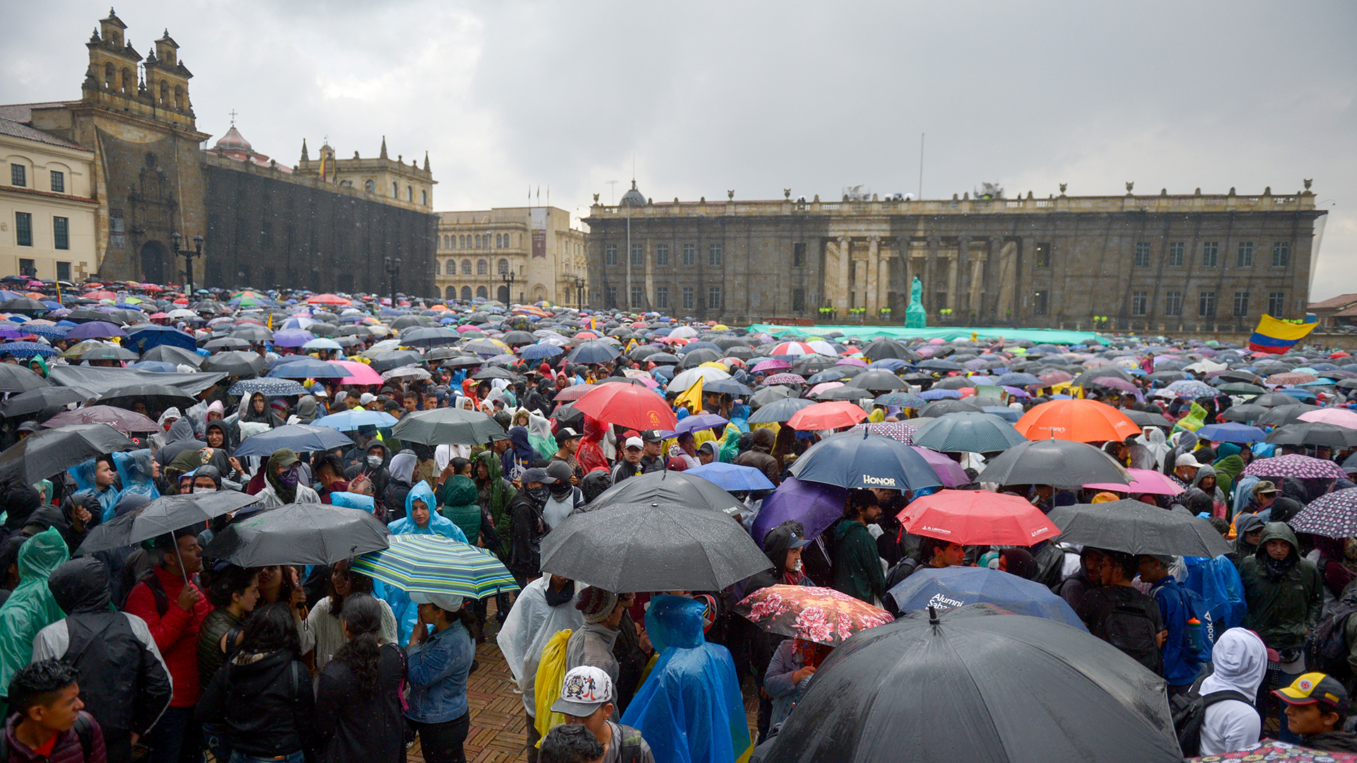 EDITORS NOTE: Graphic content / People demonstrate under pouring rain at Bolivar square in Bogota, on November 21, 2019, during a nationwide strike called by students, unions and indigenous groups to protest against the government of Colombia's President Ivan Duque. (Photo by RAUL ARBOLEDA / AFP)