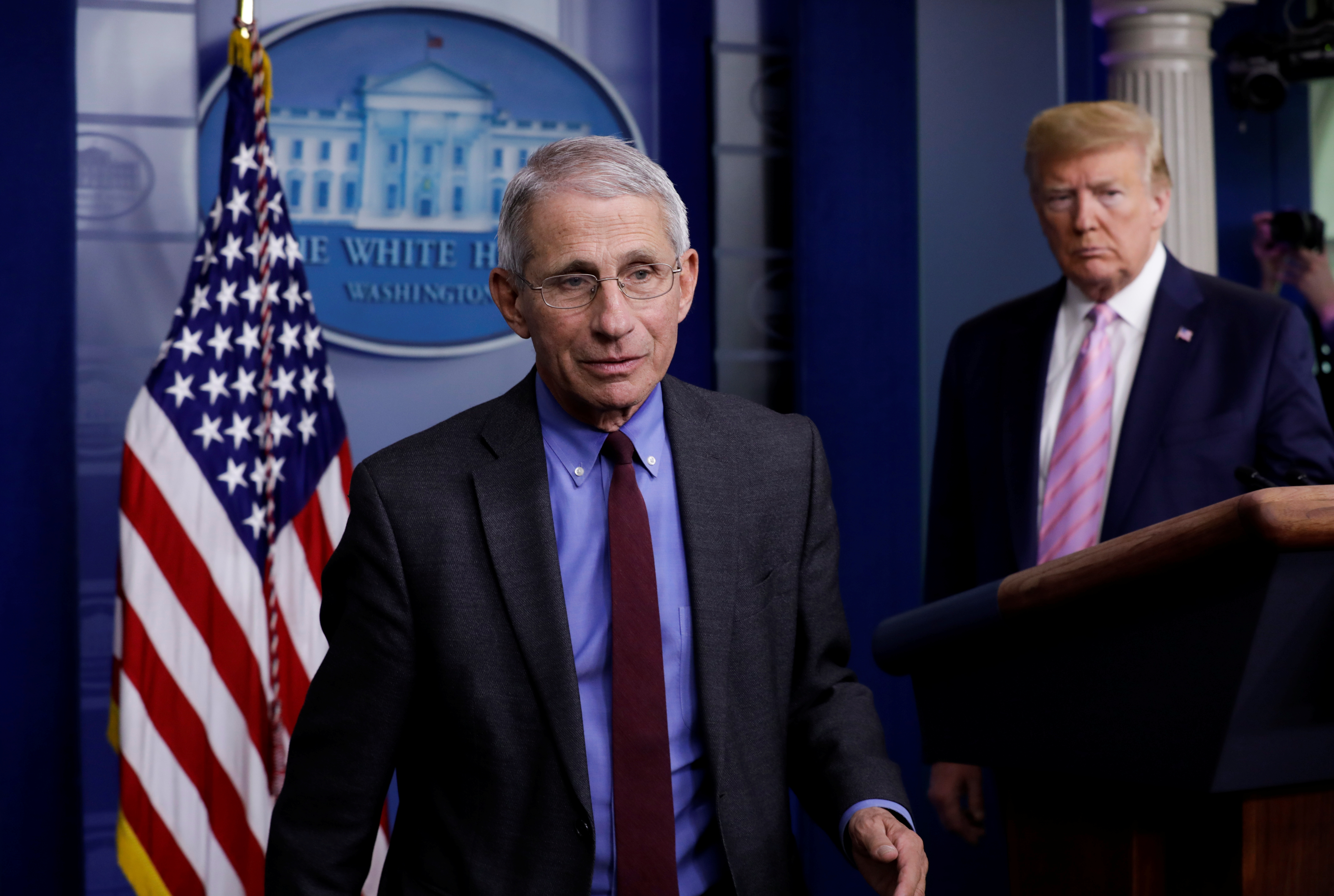 El director del Instituto Nacional de Alergia y Enfermedades Infecciosas, Anthony Fauci. De fondo, Donald Trump.
