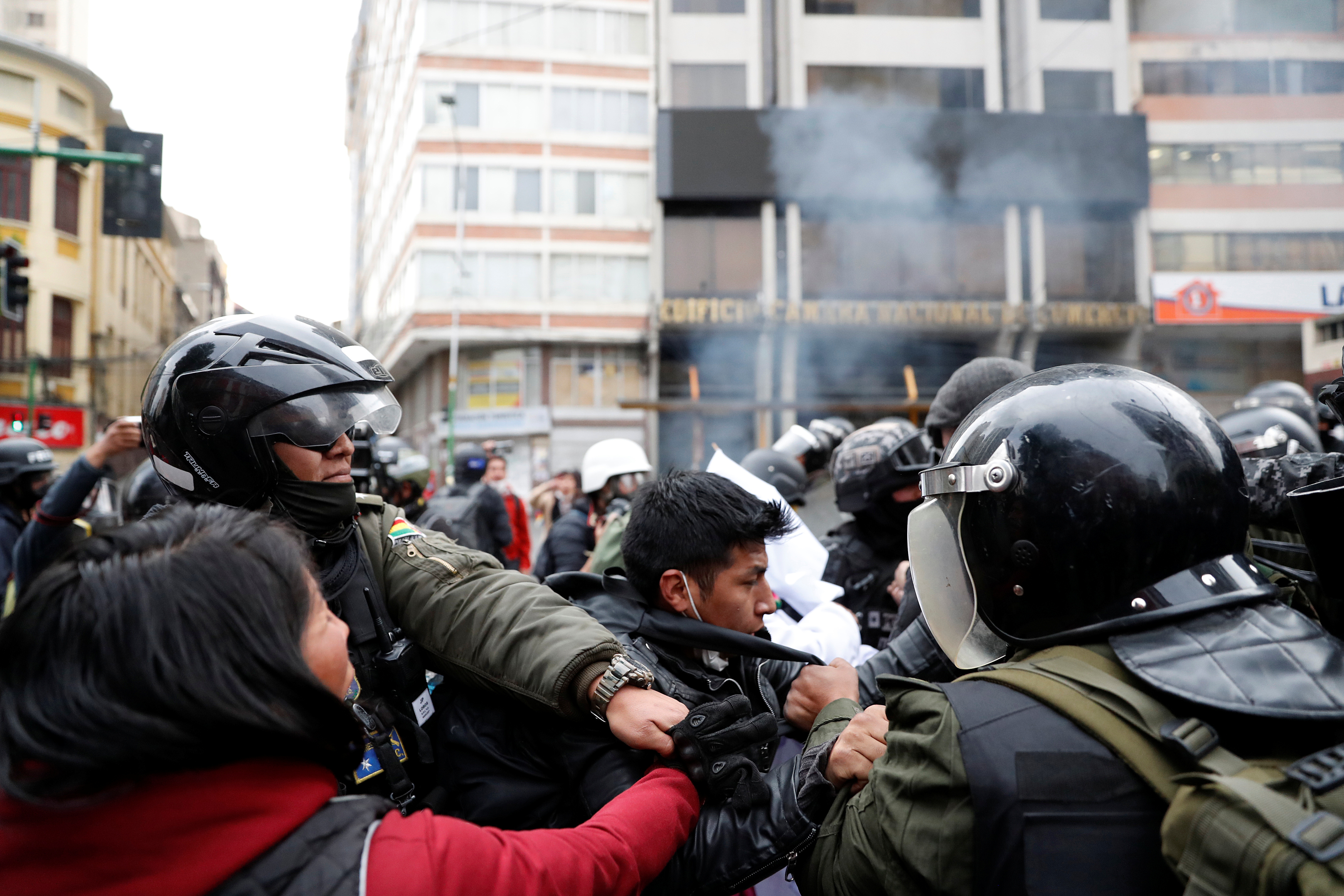 A demonstrator scuffles with members of the security forces during clashes between supporters of former Bolivian President Evo Morales and security forces, in La Paz, Bolivia November 13, 2019. REUTERS/Carlos Garcia Rawlins