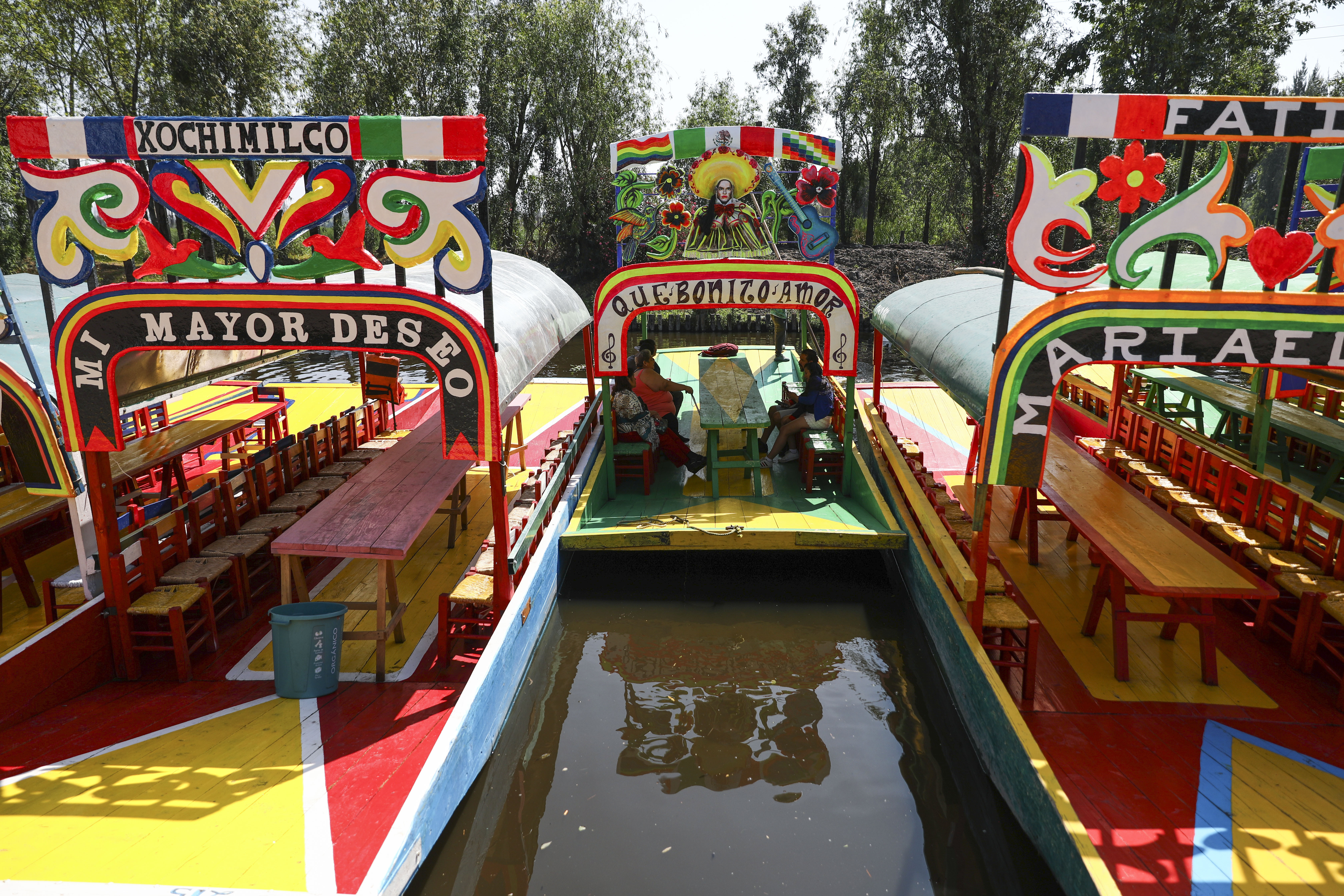 Los visitantes viajan en una trajinera, uno de los botes de madera pintados populares entre los turistas que recorren los canales en el distrito de Xochimilco de la Ciudad de México, el domingo 22 de marzo de 2020.