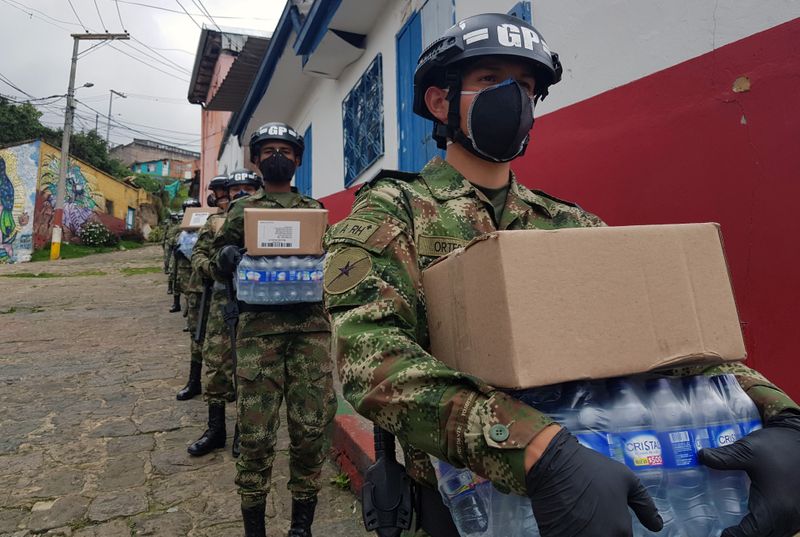 Soldados del Ejército de Colombia usando tapabocas y guantes cargan cajas con alimenros y agua para entrgar a familias pobres durante la cuarentena por coronavirus en Bogotá, Colombia, 17 de abril, 2020. REUTERS/Luis Jaime Acosta