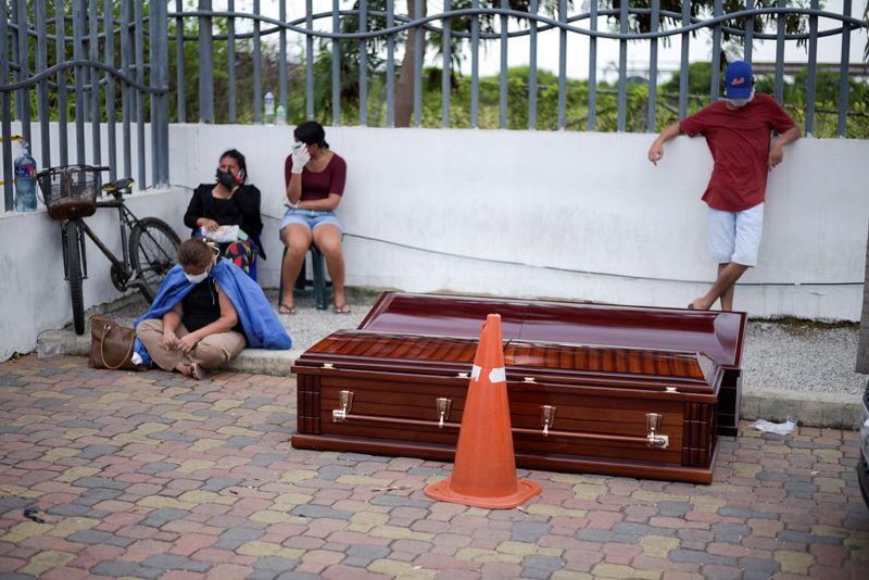 Personas esperan al lado de cajones fúnebres en el Hospital General Guasmo Sur luego de que Ecuador reportara nuevos casos de la enfermedad de coronavirus (COVID-19), en Guayaquil (REUTERS/Vicente Gaibor del Pino)
