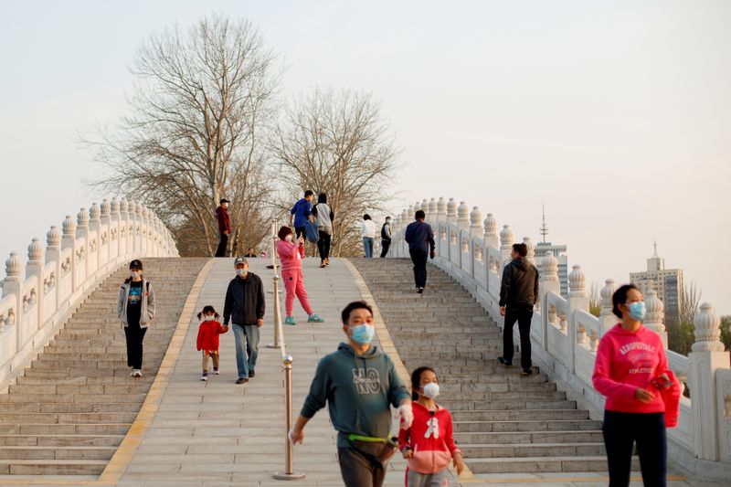 Foto del lunes de un grupo de personas usando máscaras protectoras contra el coronavirus paseando por Pekín.
Mar 23, 2020. REUTERS/Thomas Peter