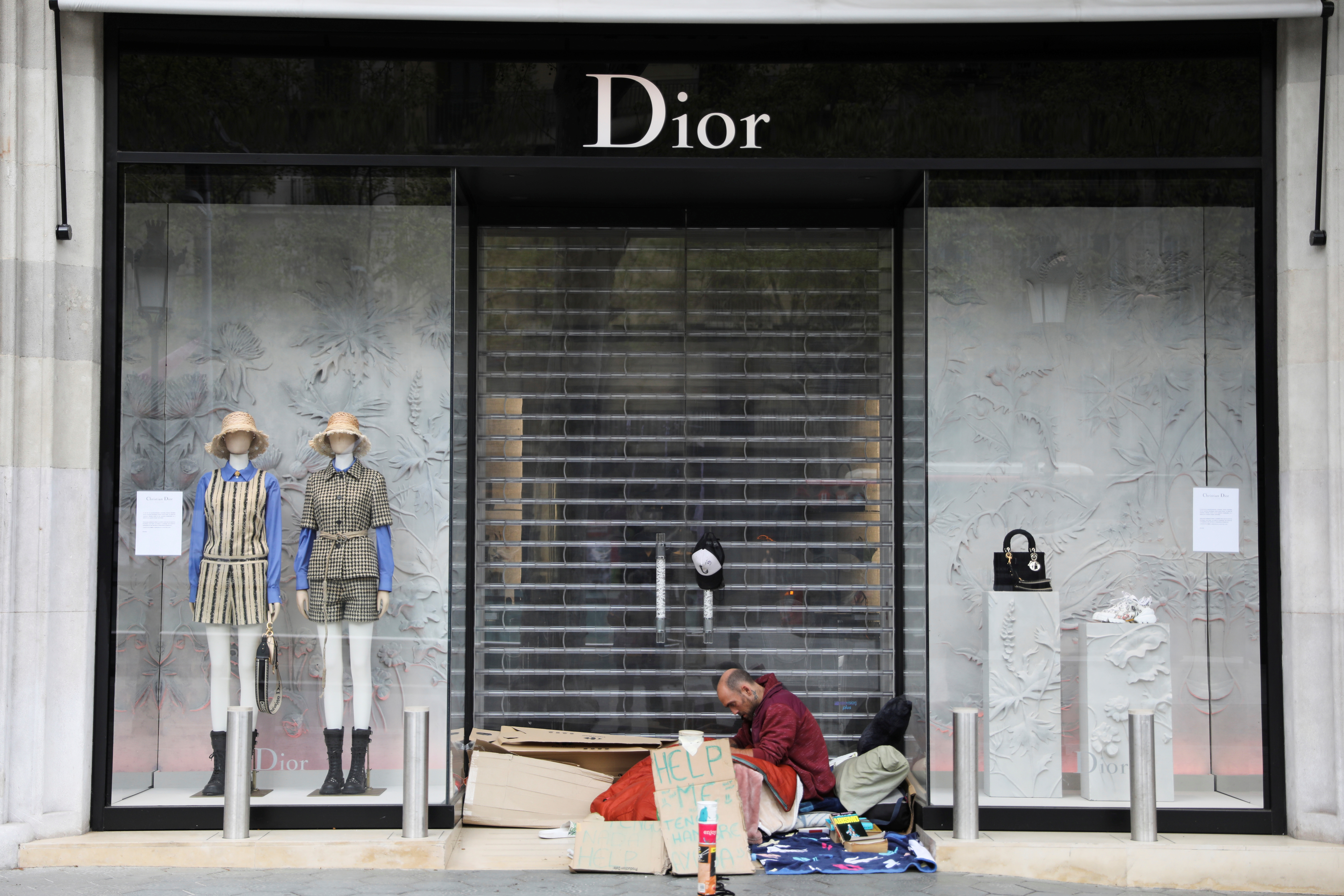 Tiendas cerradas y gente en la calle durante la cuarentena en Barcelona, España (REUTERS/Nacho Doce)