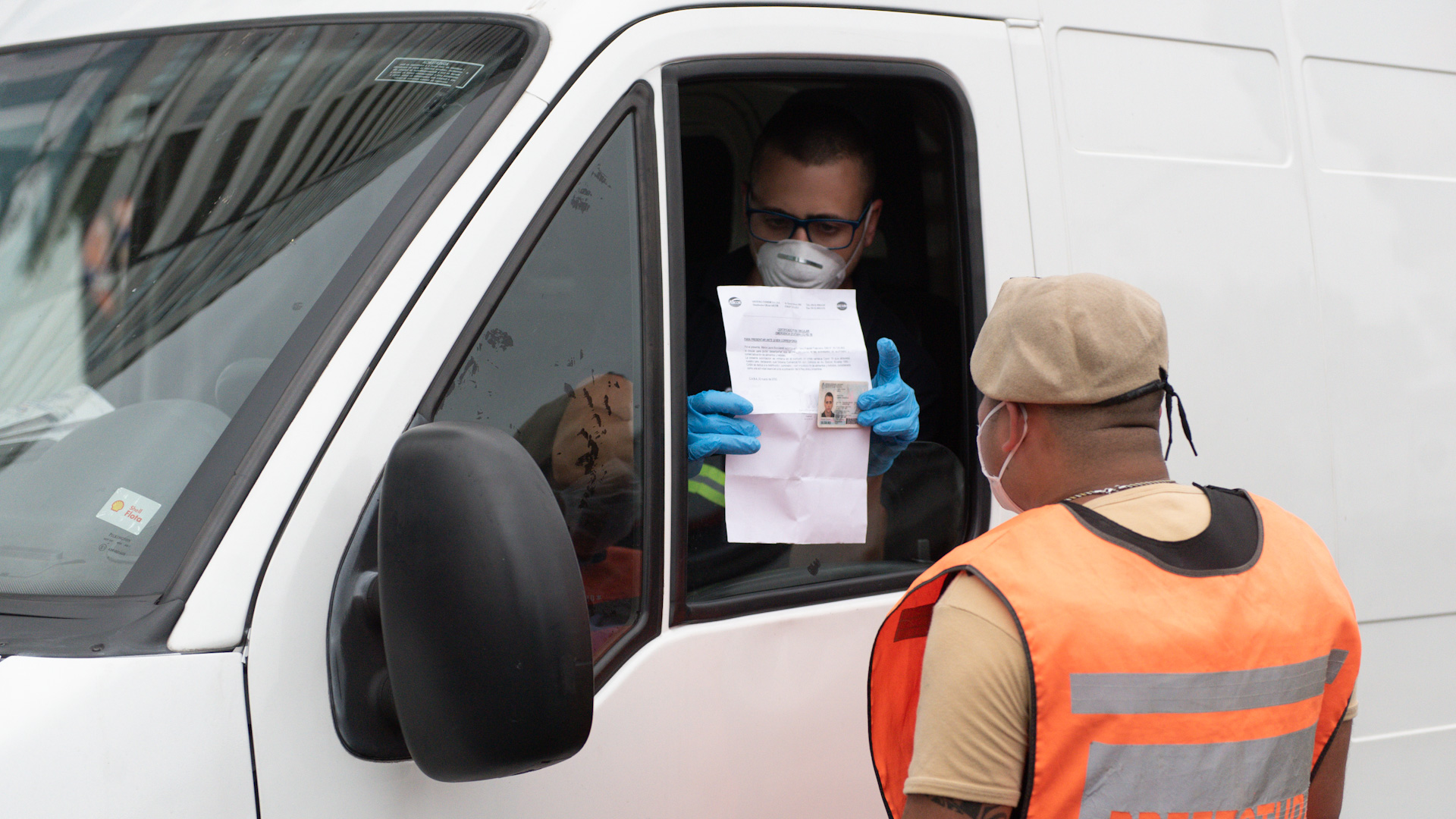 Un chofer le muestra a personal de Prefectura su permiso para circular y el documento de identidad