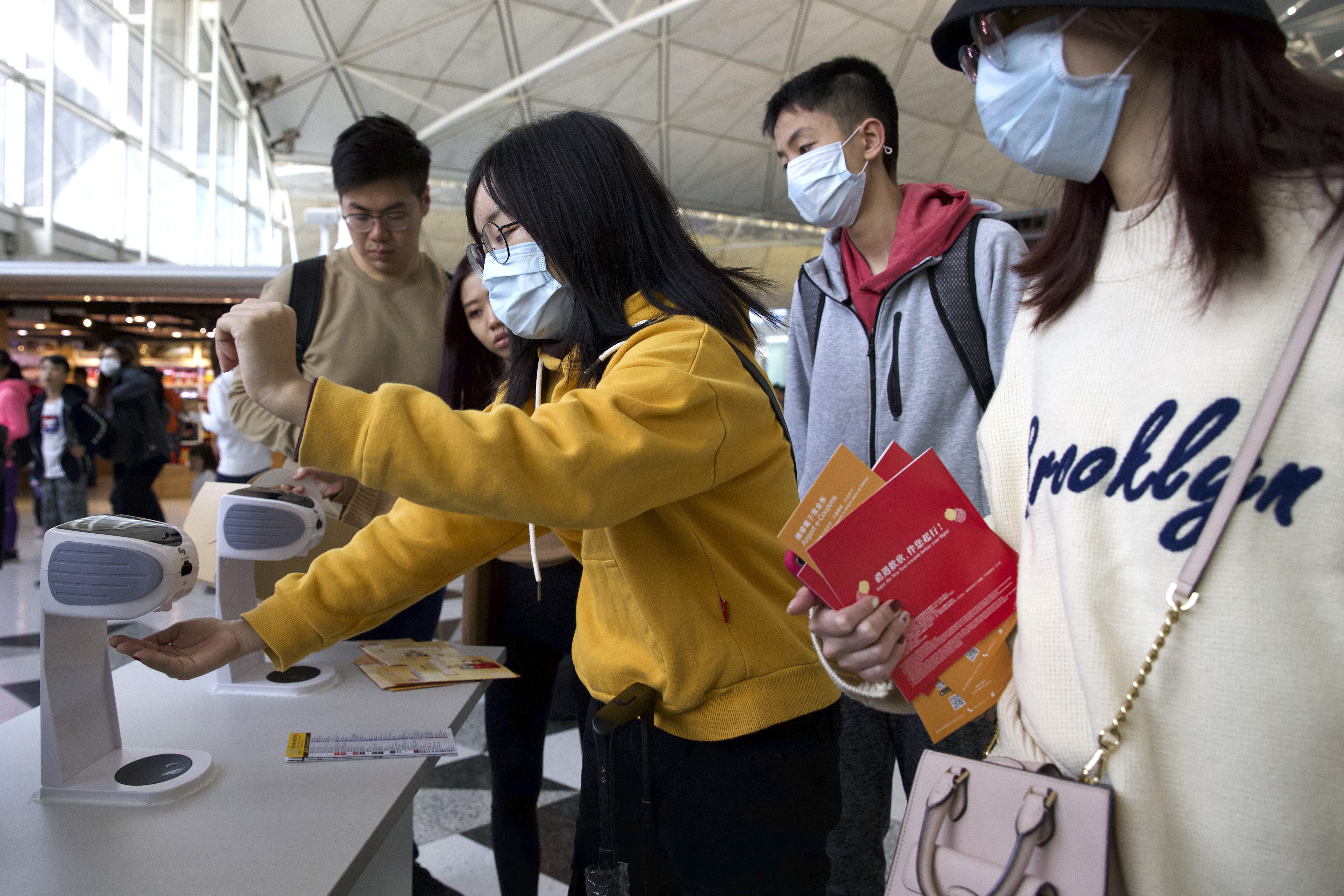 Viajeros con máscaras faciales se reúnen en el aeropuerto internacional de Hong Kong en Hong Kong, el martes 21 de enero de 2020. (Foto AP / Ng Han Guan)