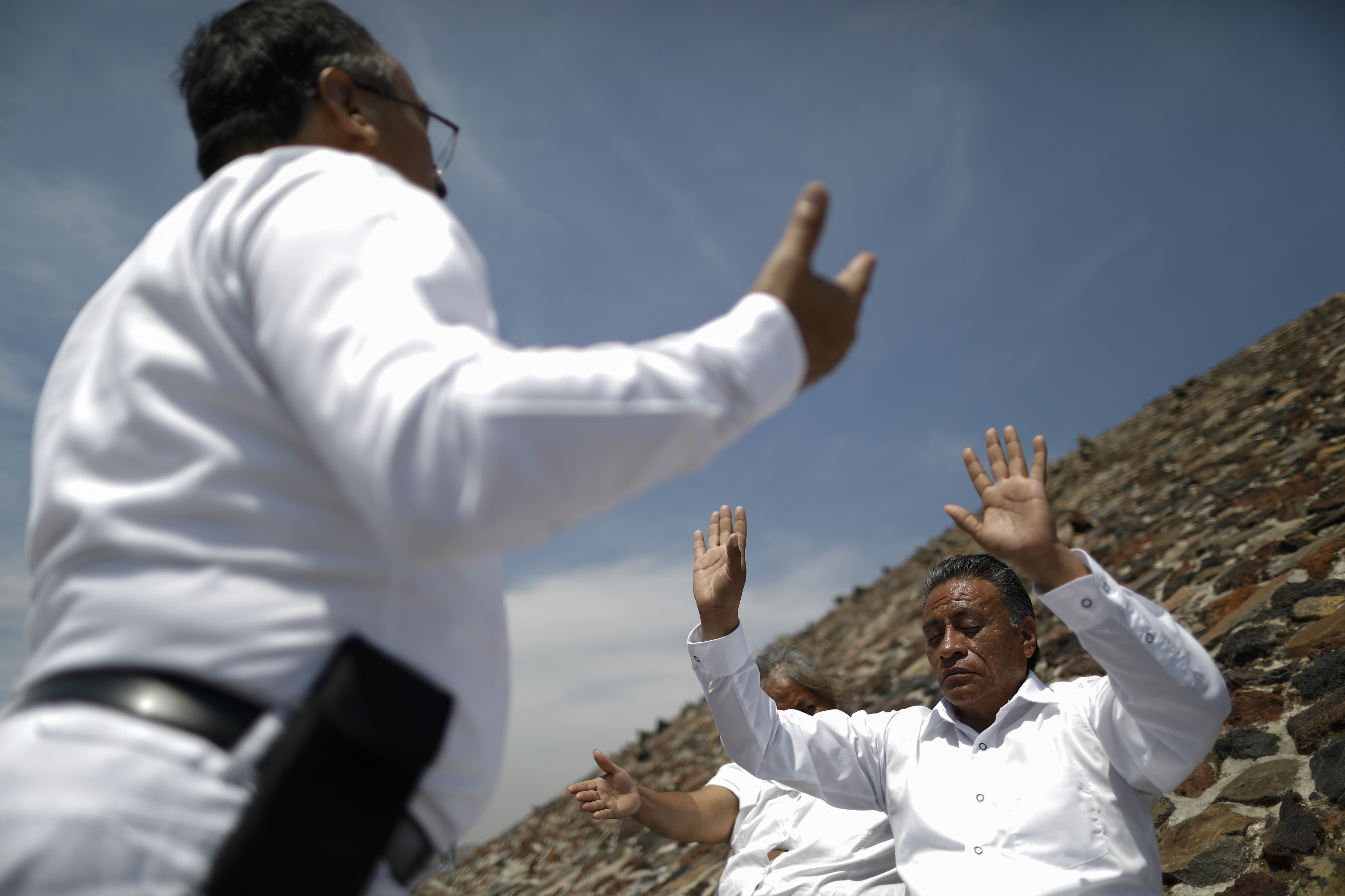 La familia Martínez de Puebla celebra el equinoccio de primavera un poco temprano, para evitar multitudes y cierres, en la cima de la Pirámide del Sol, en Teotihuacan, México, el jueves 19 de marzo de 2020.