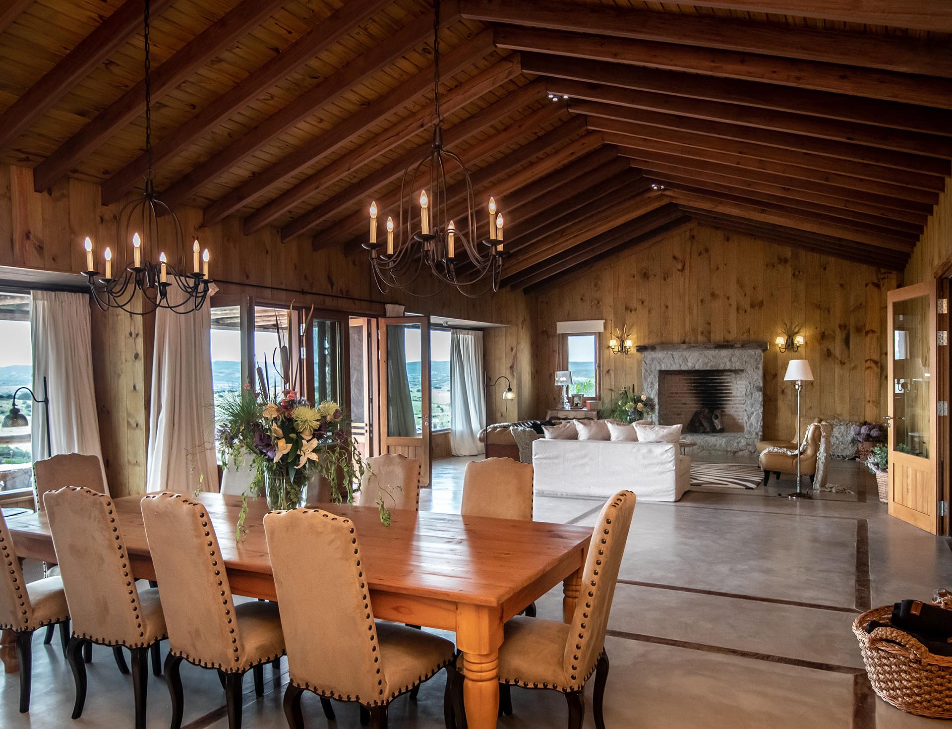 La casa cuenta con una gran sala de estar con maderas recuperadas, y una chimenea rodeada de piedra y grandes ventanales