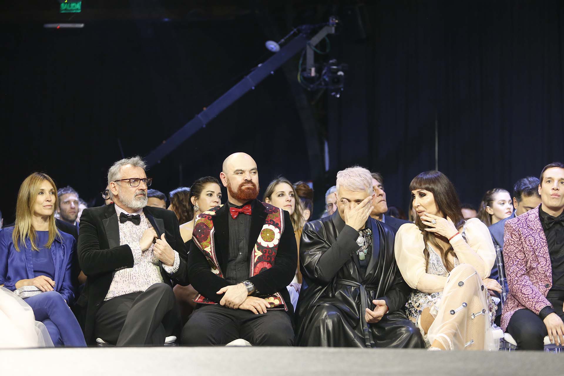 Benito Fernández, su novio Zeus y Moria rodeada de sus colaboradores. En esa fila nadie dejó de comentar lo que ocurría arriba y abajo del escenario
