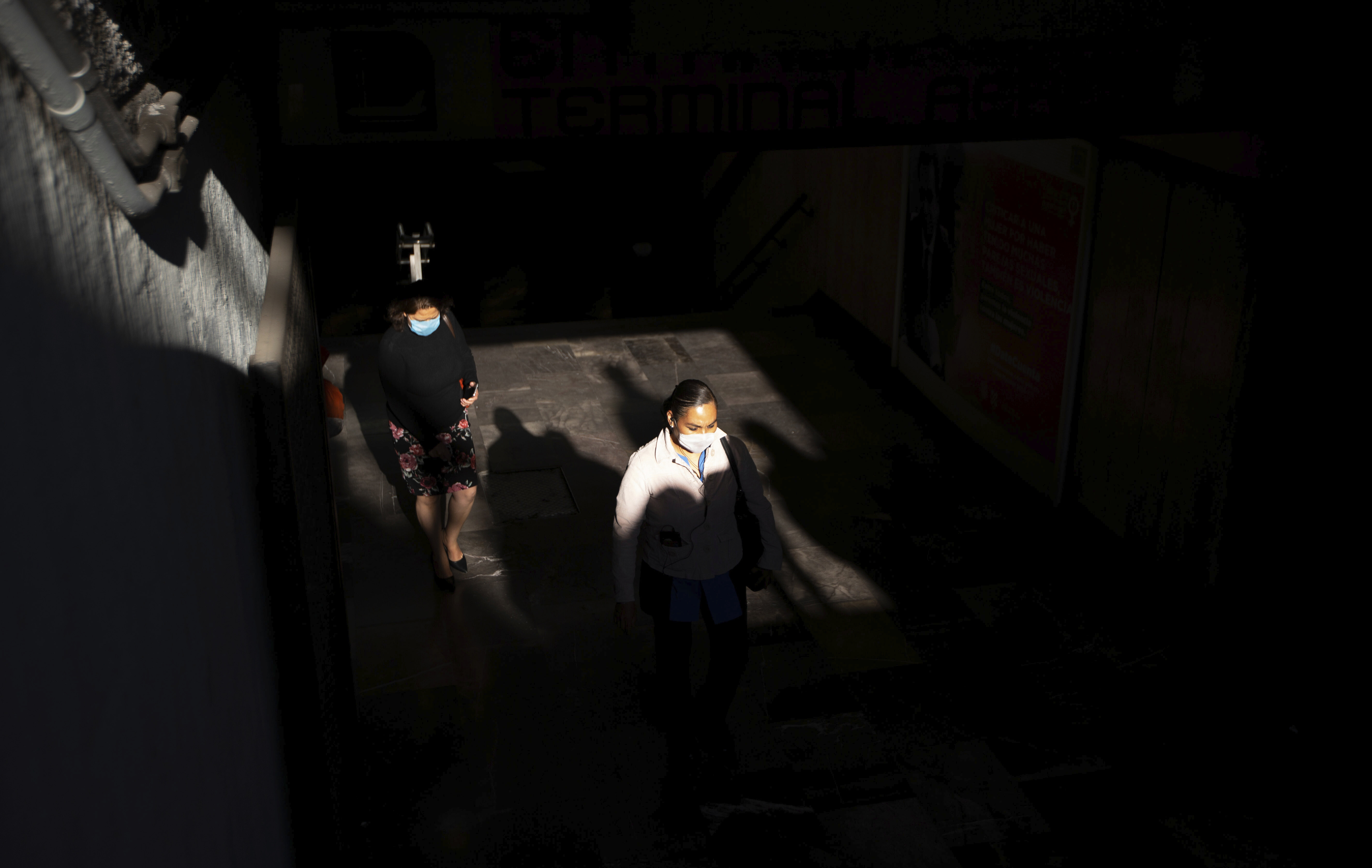 Algunos peatones usan máscaras faciales protectoras salen de una estación de metro en la Ciudad de México, el miércoles 25 de marzo de 2020.