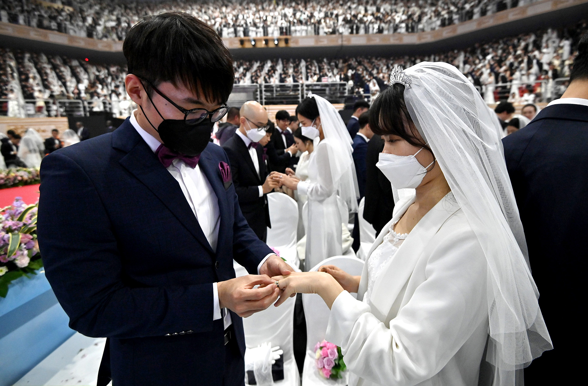 Las parejas con máscaras protectoras asisten a una ceremonia de boda masiva organizada por la Iglesia de Unificación en el Centro Mundial de la Paz de Cheongshim en Gapyeong el 7 de febrero de 2020 (Jung Yeon-je / AFP)