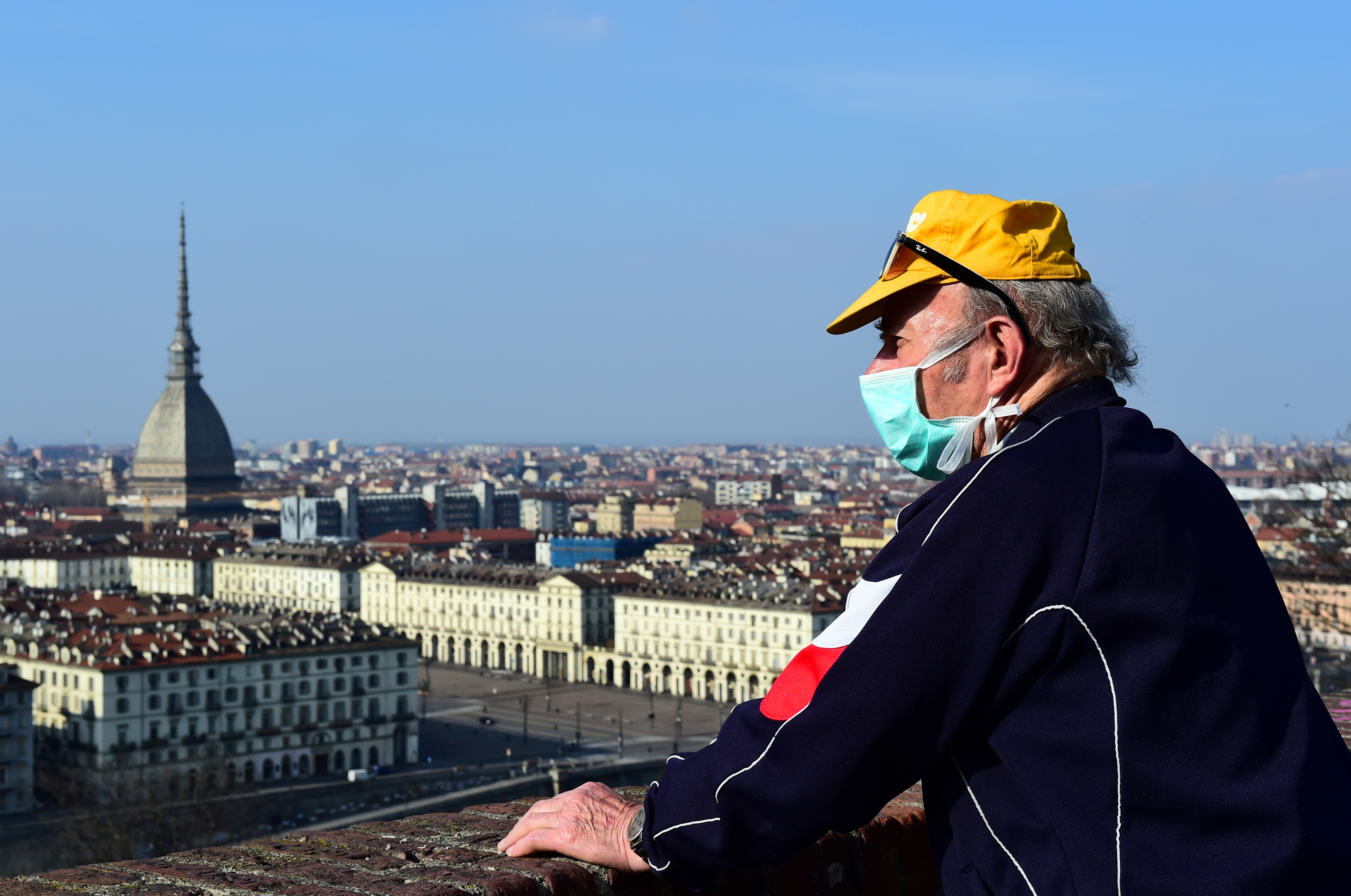 Un hombre con barbijo mira el centro de Turín desde el Monte dei Cappuccini, en el cuarto día de un encierro sin precedentes en toda Italia impuesto para frenar el brote de coronavirus, en Turín, Piamonte (Reuters/ Massimo Pinca)