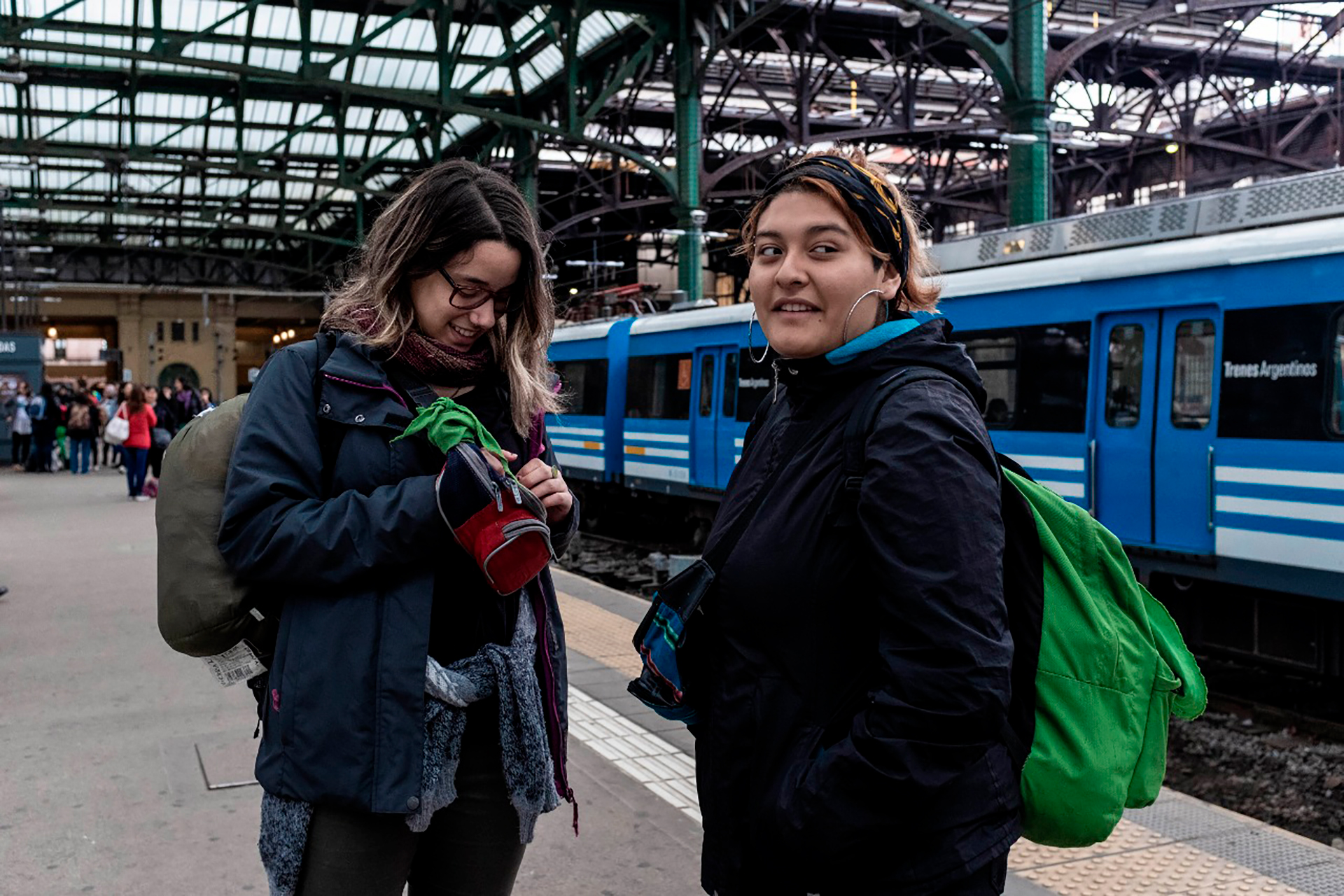 Mira y su amiga Kiara Sánchez esperan al tren para dirigirse al Encuentro Nacional de Las Mujeres en La Plata.